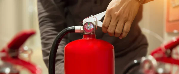 İtfaiyeci, yangın söndürme tankının sapını kontrol ediyor. Bina konseptleri acil durum, güvenlik ve itfaiye eğitimi için..
