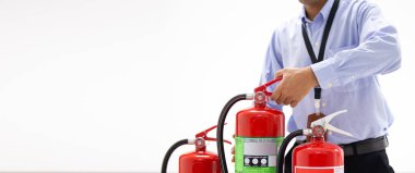 Bina konseptindeki kırmızı yangın söndürme tankının sapını kontrol eden memur acil durum, güvenlik ve itfaiye eğitimi konseptini kontrol ediyor..