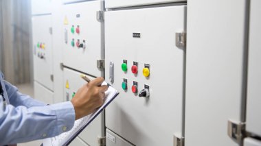 Elektrik mühendisi, ana güç dağıtım odasındaki elektrik akımını kontrol etmek için havalandırma kontrol paneli (AHU) ya da yükleme merkezi kabinesindeki elektrik akımını kontrol ediyor..