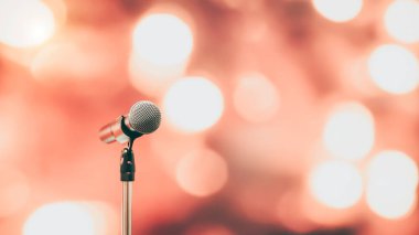 Toplum önünde konuşma geçmişi, konuşma sunumu için mikrofonu kapatın. Teknoloji bulanık arka planlı sahne performansı..