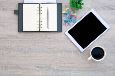 Çalışma alanı kompozisyonu ve ev kavramlarından çalışma alanı kopyalamak için kalem ve ofis ekipmanı içeren üst görünüm masası ve bilgisayar tableti veya not defteri takvimine sahip akıllı telefon.