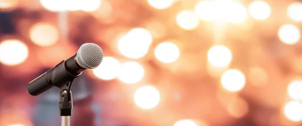 Halka açık konuşma arkaplanı, konuşma sunumu için mikrofonu kapatın bulanık ve bokeh ışık arkaplanlı sahne performansı.