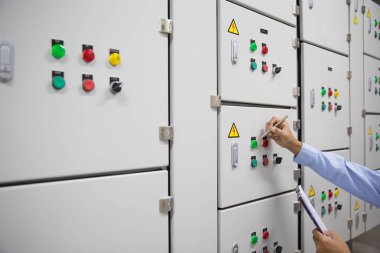 Elektrik mühendisi, bakım güç sistemi dağılımı için klima yükleme merkezi kabinesi için elektrik voltajını kontrol ediyor..