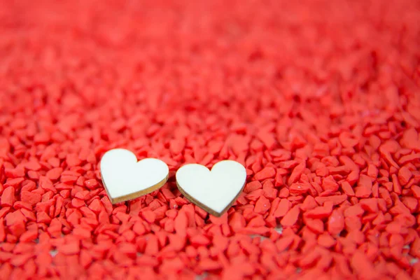 Close-up two hearts for love symbol on a red sand background. Concept the day of love 14 February happy valentine\'s day.