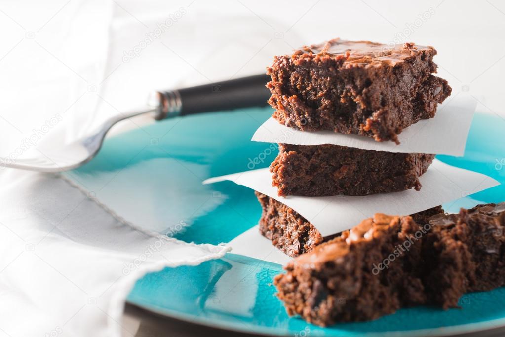 Chocolate fudge brownies stacked on a plate