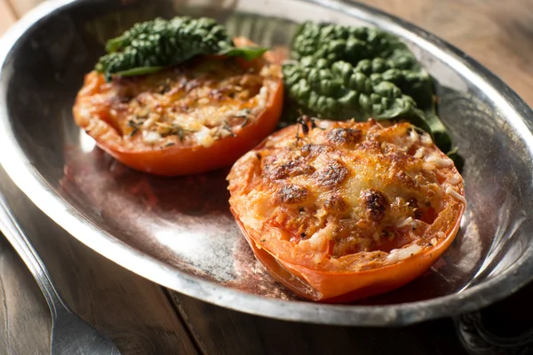 Запеченные томатные половинки покрыты сыром и специями — стоковое фото