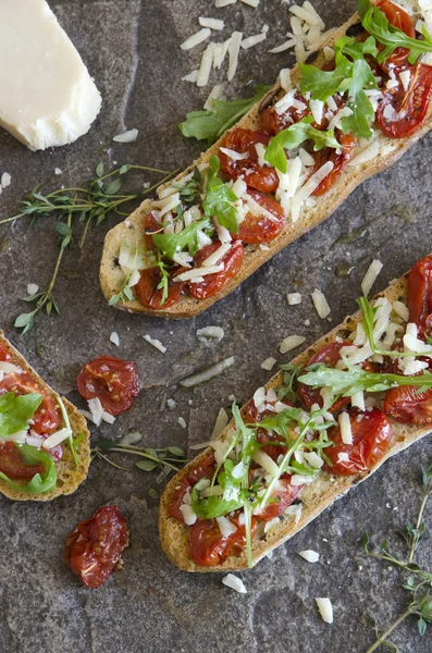 Geroosterde bruschettas met tomaten en raket — Stockfoto