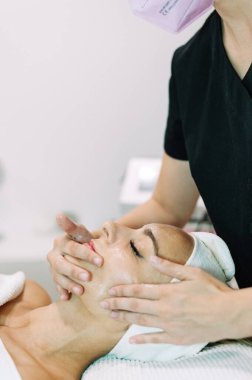 Kadın güzellik salonunda yüz serumuyla tedavi görüyor.