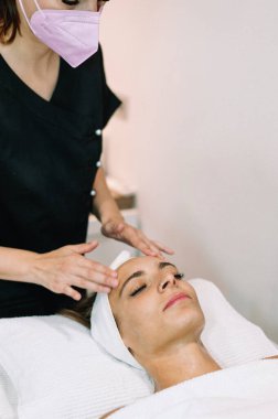 Kadın güzellik salonunda yüz serumuyla tedavi görüyor.