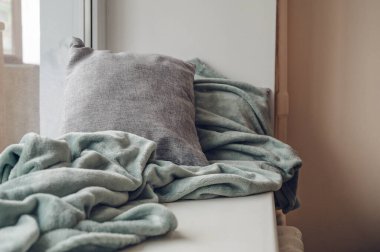 Yumuşak yastıklar ve beyaz pervazda yumuşak ekose kumaşlar. Sıcak yastıklar.