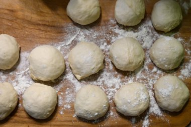 Ahşap tezgahta çiğ hamur topları ve un manzarası. Hamur işleri için hazırlama.