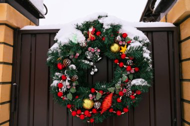 Özel bir evin çit kapısında Noel çelengi var. Güzel dekorasyon.