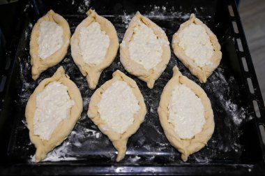 Tepside un bulunan çiğ khachapuri manzarası. Peynir ve hamur. Pişirmeye hazır..