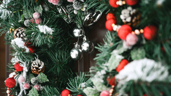 Close-up of Christmas wreath with snow on the door. Beautiful decoration.