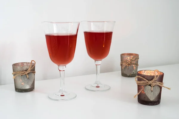 ワインとテーブルの上に木製の心を持つキャンドルとグラスのカップルのクローズアップ ロマンチックな構成 — ストック写真