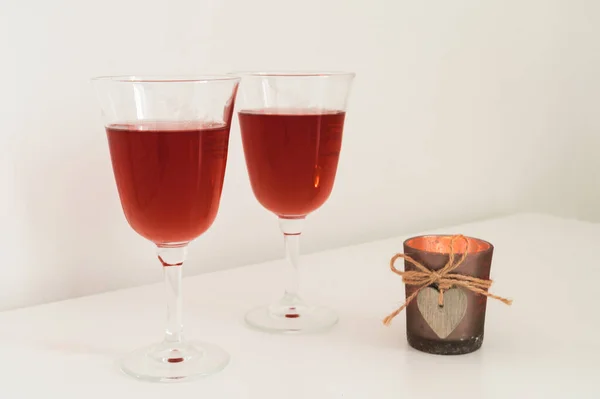 テーブルの上に木製の心を持つワインとキャンドル付きのグラスのカップルのクローズアップ ロマンチックな構成 — ストック写真