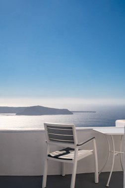Lüks otelin terasında sandalye ve masa. Caldera manzarası. Santorini Adası, Yunanistan. Volkan. Ege Denizi. Beyaz mimari.