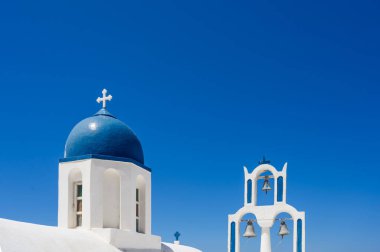 Santorini adasındaki geleneksel Rum Ortodoks kilisesinin beyaz ve mavi çan kulesi. Arka planda mavi gökyüzü.