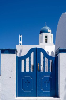 Santorini adasındaki geleneksel Rum Ortodoks kilisesine küçük tahta kapı. Kapalı mavi kapı. Güneşli bir gün. Mavi gökyüzü. Kimse..
