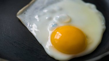 Yumurta yağsız bir kızartma tavasında kızarır. Sağlıklı kahvaltı. Yakın plan..
