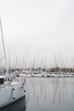 Limandaki yat ve tekneler. Rıhtımda beyaz yelkenli yatlar. Deniz yat kulübü. Ege Denizi. Atina, Yunanistan. Bulutlu bir gün.