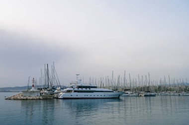 Limandaki yat ve tekneler. Rıhtımda beyaz yelkenli yatlar. Deniz yat kulübü. Ege Denizi. Atina, Yunanistan. Bulutlu bir gün.