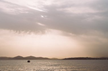 Bulutlu bir günde Atina 'daki Ege Denizi' nin güzel manzarası. Yalnız tekne. Sisin içindeki adaların siluetleri. Hiç kimse. Yunanistan.