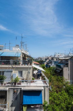Atina, Yunanistan şehir manzarası. Tipik şehir mimarisi. Canlı binaların dışı. Teraslarda güneş panjurları. Güneşli bir yaz günü. Yeşil ağaçlar. Çatı destekli antenler.