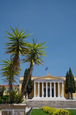 Atina Ulusal Bahçeleri 'ndeki Zappeion Salonu' nun ön manzarası. Mavi gökyüzü. Yeşil ağaçlar. Klasik mimari.