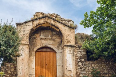 Yeşil ağaçlı Medrese Kapısı. Arka planda bulutlu mavi gökyüzü. Eski mimari. Avrupa tarihi. Atina, Yunanistan 'da dönüm noktası.