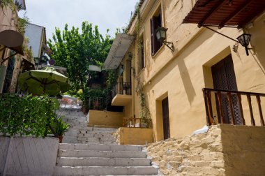 Atina 'nın Plaka ilçesi. Merdivenleri olan boş bir cadde. Yeşil ağaçlar.