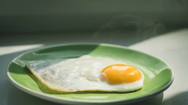 一个刚煮熟的热煎蛋放在一个绿色盘子里 健康的早餐四 后续行动 — 图库照片