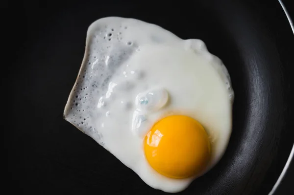 鸡蛋放在一个没有油的煎锅里煎 健康的早餐特写 从上面看 — 图库照片