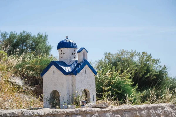 Proskinitari. A small blue and white church by the road in Greece. SUnny summer day.