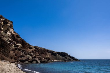 Yunanistan 'ın Santorini adasındaki Akrotiri köyü yakınlarındaki kırmızı kumsal manzarası. Büyük taşlar ve kayalar. Ege Denizi, Kiklad. Güzel doğa..