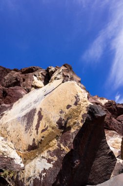 Santorini sahilinde büyük kırmızı ve sarı kayalık bir uçurum. Uzaylı manzarası.