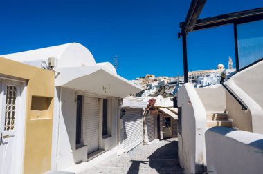 Thira, Santorini Adası 'ndaki boş dar bir sokak. Coronavirus tecridi sırasında kapanan dükkanlar. Beyaz Yunan mimarisi /