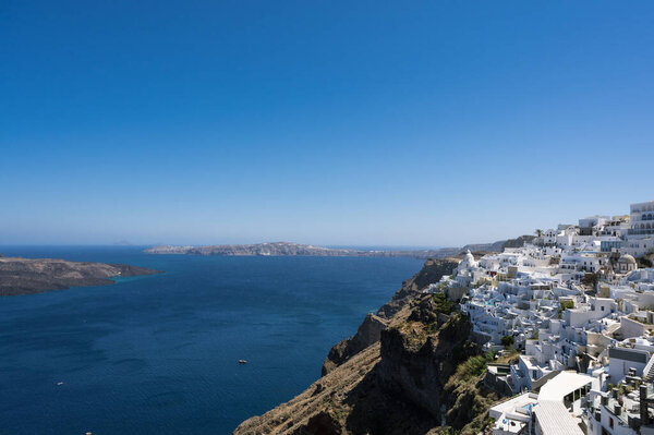 Scenic cityscape of Thira. city on the hill. White architecture. Santorini island, Greece. Luxury tourism. Caldera sea view.