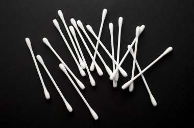 Siyah arka planda bir sürü pamuk çubuğu var. Üst görünüm.