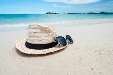 Hasır Şapka ve güneş gözlüğü. Yaz tatili, seyahat ve tatil konsepti olarak güzel kumsal. Tatil konsepti. İleti için alanı kopyala.