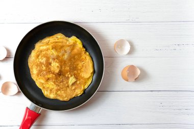 Üst manzara Tayland omleti mi yoksa küçük kızarmış yumurta mı? Beyaz masadaki yumurta kabuğunun yanında. Tayland sokak yemeği. Geleneksel Tayland usulü yemek. Ev yapımı yemek. Nefis ev yapımı yemekler..