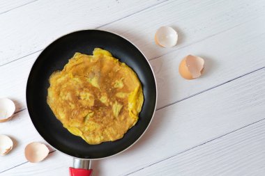 Üst manzara Tayland omleti mi yoksa küçük kızarmış yumurta mı? Beyaz masadaki yumurta kabuğunun yanında. Tayland sokak yemeği. Geleneksel Tayland usulü yemek. Ev yapımı yemek. Nefis ev yapımı yemekler..