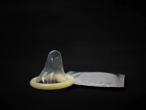 Grädde Färg Kondom Med Grå Paket Svart Bakgrund Begreppet Könsskydd — Stockfoto