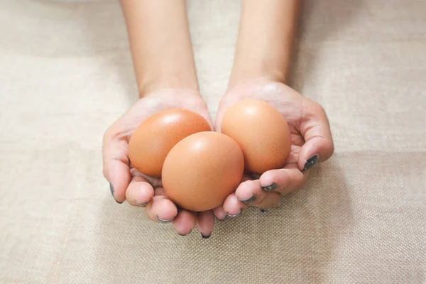 Close Mãos Mulher Jovem Segurando Ovos Nas Mãos Fundo Saco — Fotografia de Stock