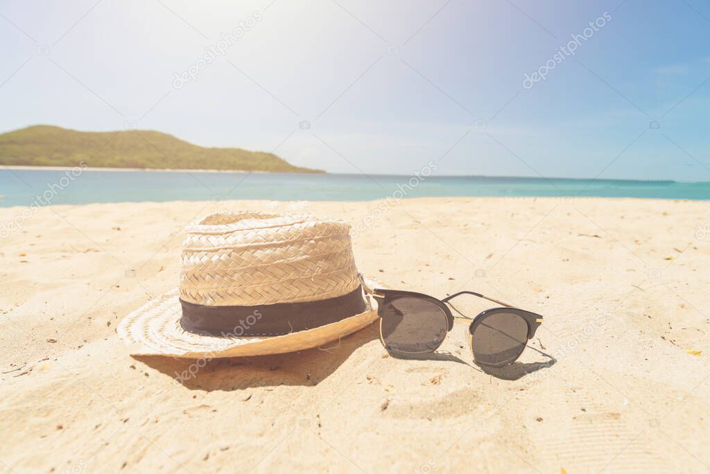 Vintage Hat and sunglasses on the beach beautiful sand beach as summertime, vacation concept.