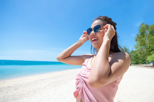 woman tan skin wearing pink tank top and straw hat with standing arms outstretched on sky. looking into the sea and fresh sky. Summer travel. Relax, Holiday and tropical, comfortable concept.