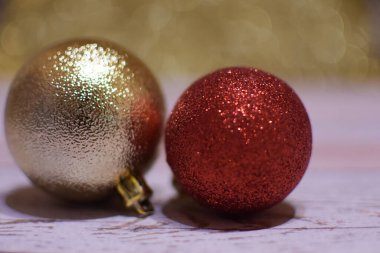 Odaklanmamış parlak bir arka planda, ahşap bir masada Noel topları.