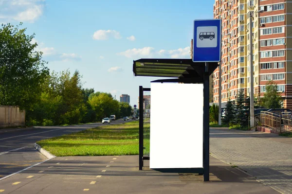 Otobüs durağındaki reklam. Şehir caddesinde bir otobüs durağında dikey beyaz reklam panosu. Dalga geç. Yaz güneşli bir gün.