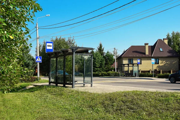 two bus stops opposite each other in summer day