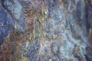 Arkaplan taş bir kayanın dokusudur. Kısmen bulanık görüntü. Altın kaplamalı mavi taş.